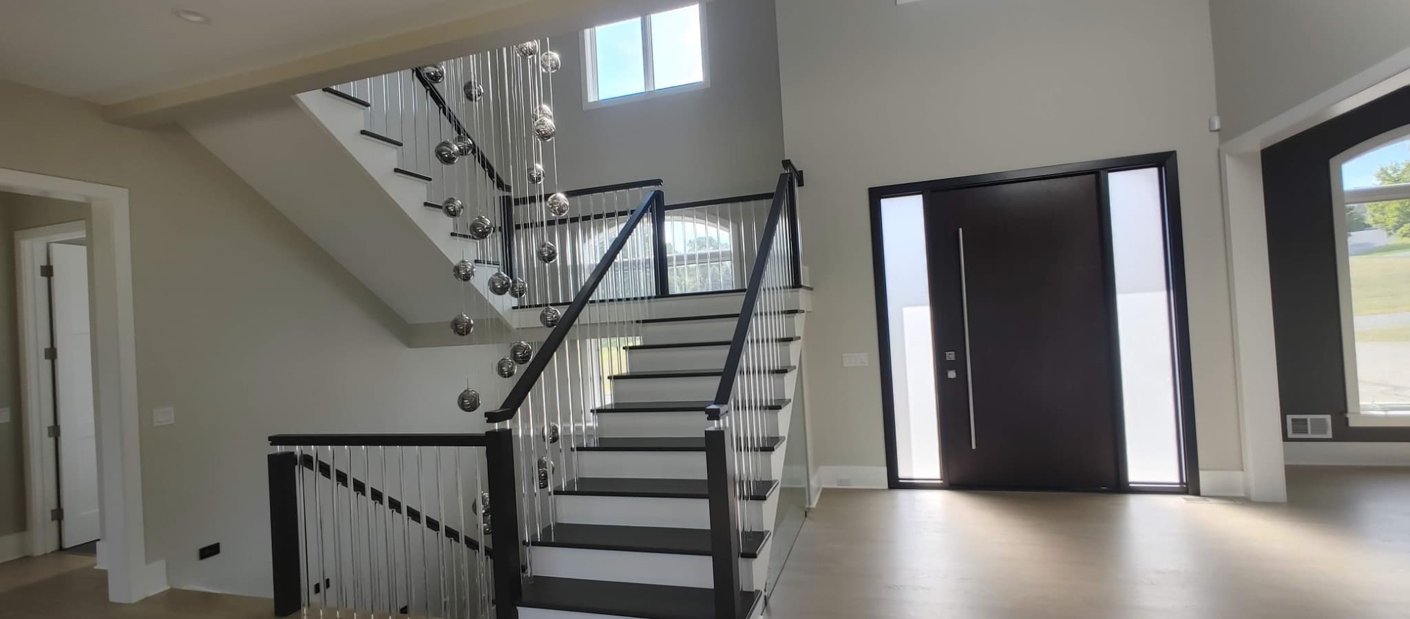 Two-story entryway with floating staircase and bubble chandelier